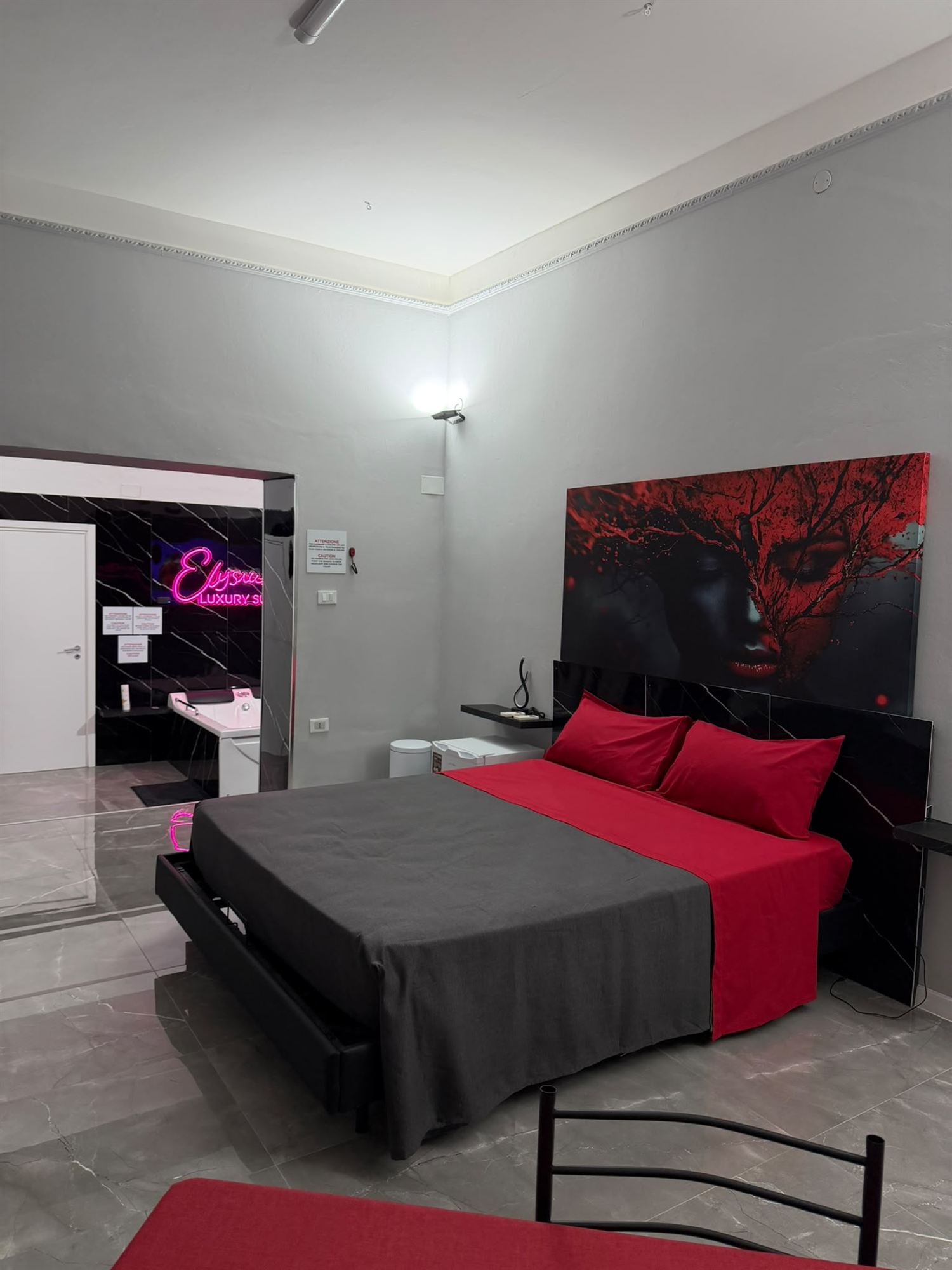 Zona notte della suite con letto matrimoniale e quadro d'autore